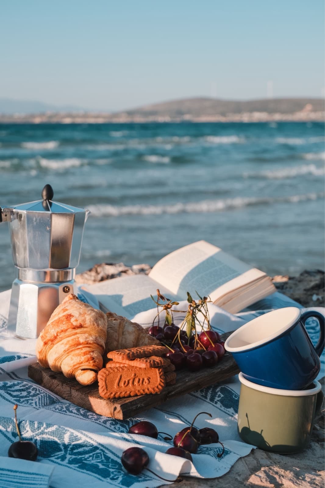 Breakfast laid out on a blanket by the sea